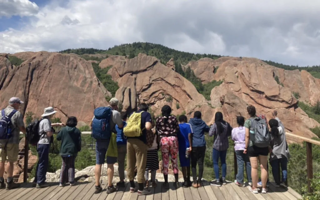 A group of people looking towards a mountain
