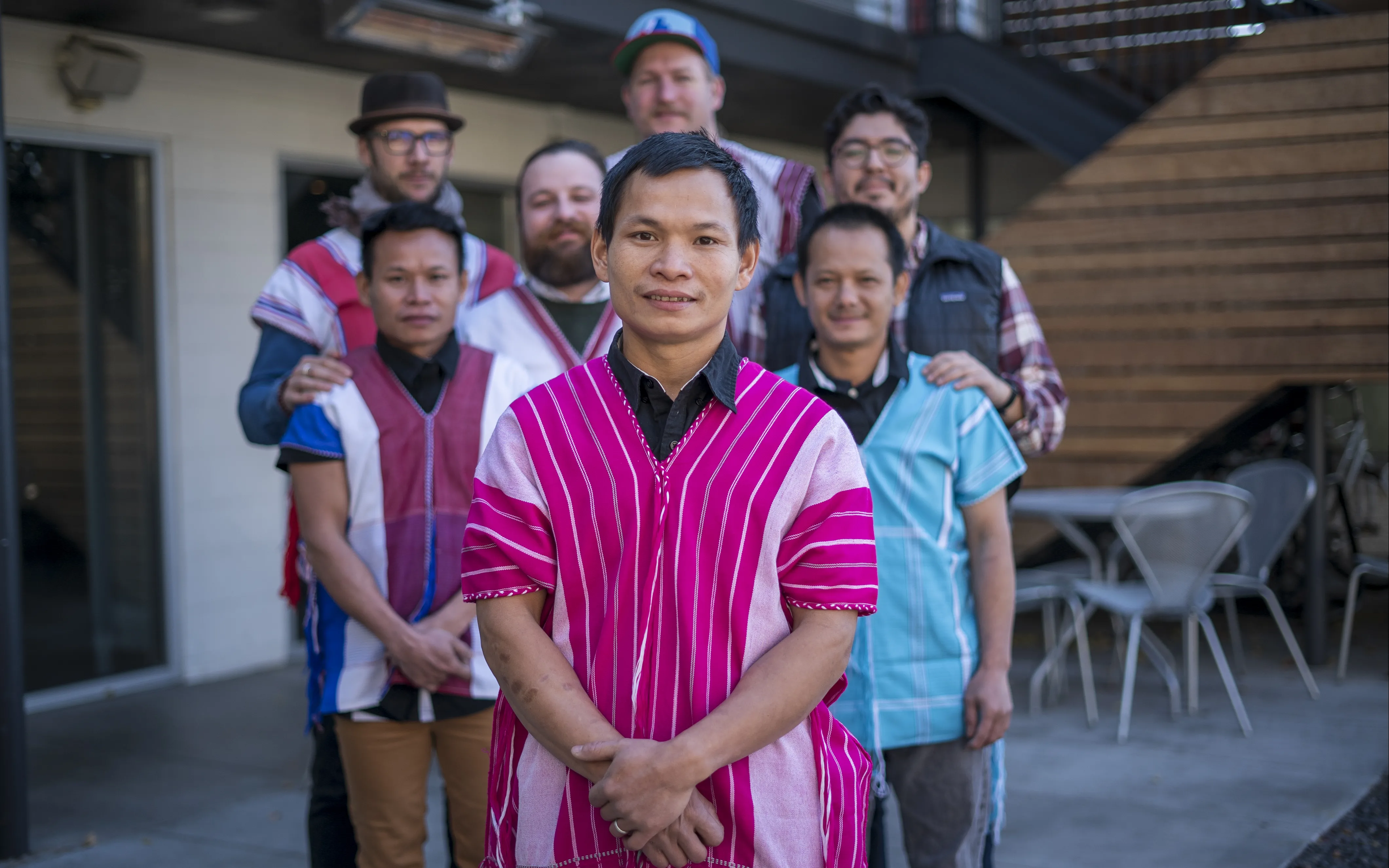 Dah Bu and his coworkers stand together for a group photo. Dah Bu and his friends are wearing traditional Burmese outfits. 