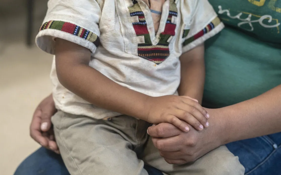 A child sits on his mother's lap
