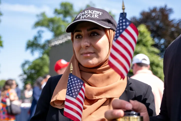 A woman stands with two miniature American flags