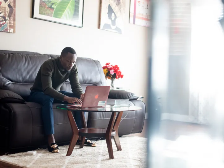A man types on a laptop computer as part of an employment program