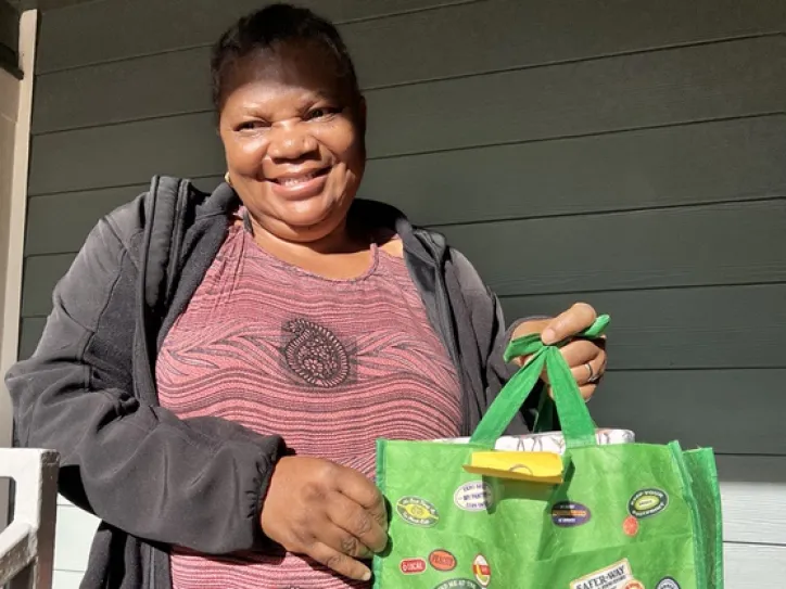 IRC client holds a bag and smiles during the Toy Drive