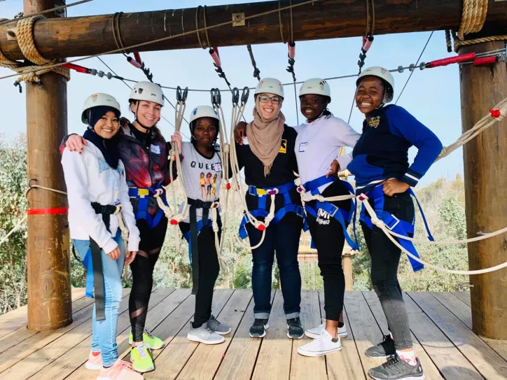 Women stand together and smile during an outdoor activity 