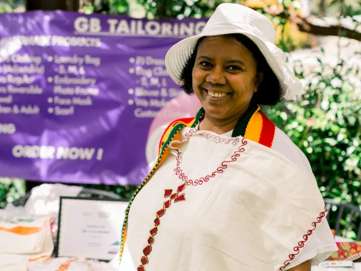 Woman smiles at an outdoor event for women's empowerment 