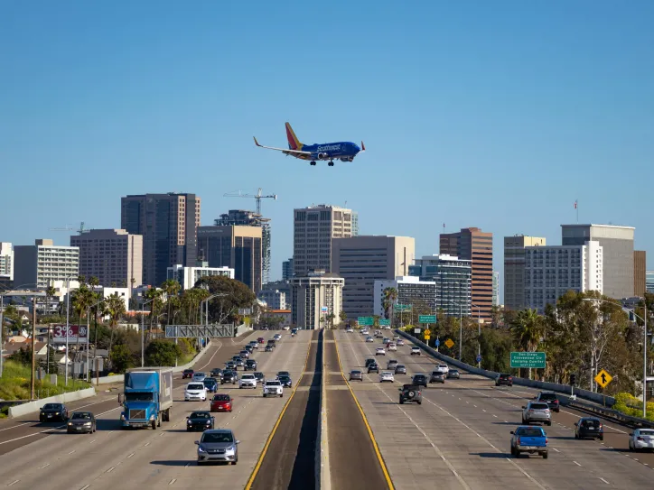 A plane flies over downtown San Diego