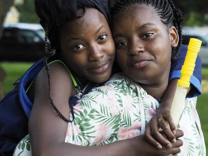 Two people smile and embrace while sitting outside 