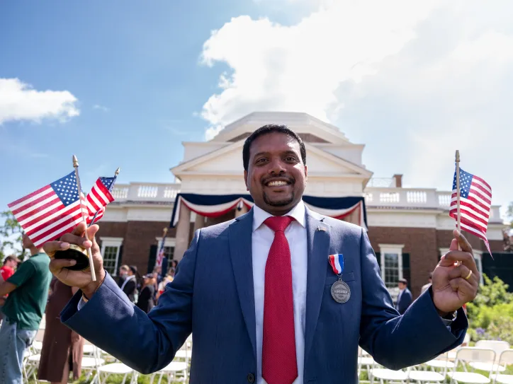 Happy man with US flagsin front of Monticello in Charlottesville, VA, USA