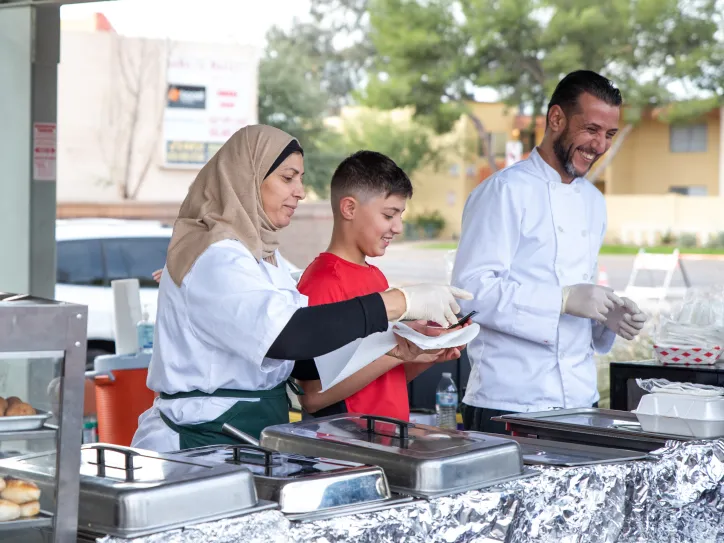 Chef and family working at food stall