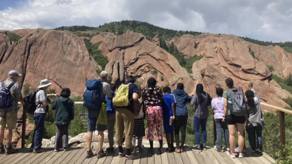 A group of people looking towards a mountain
