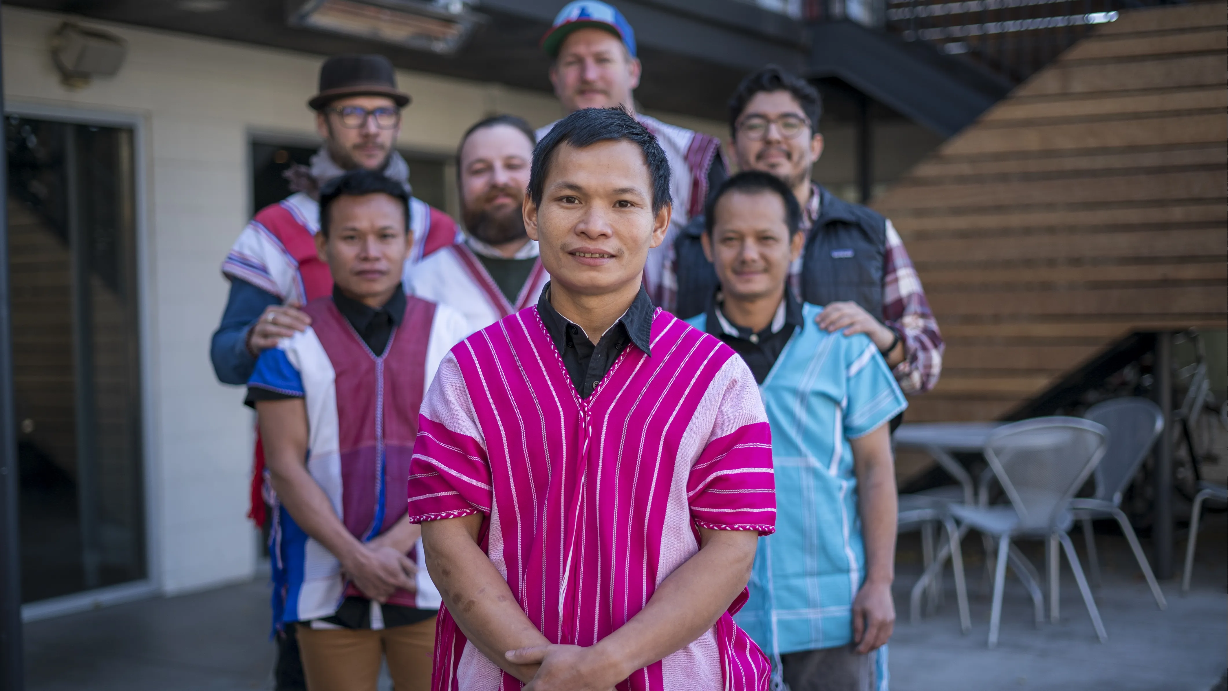 Dah Bu and his coworkers stand together for a group photo. Dah Bu and his friends are wearing traditional Burmese outfits. 