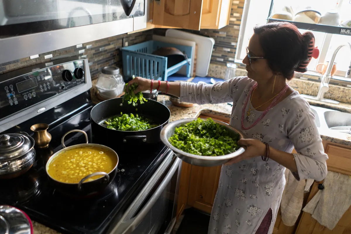 Geeta Sharma cooks lunch for her family in her kitchen