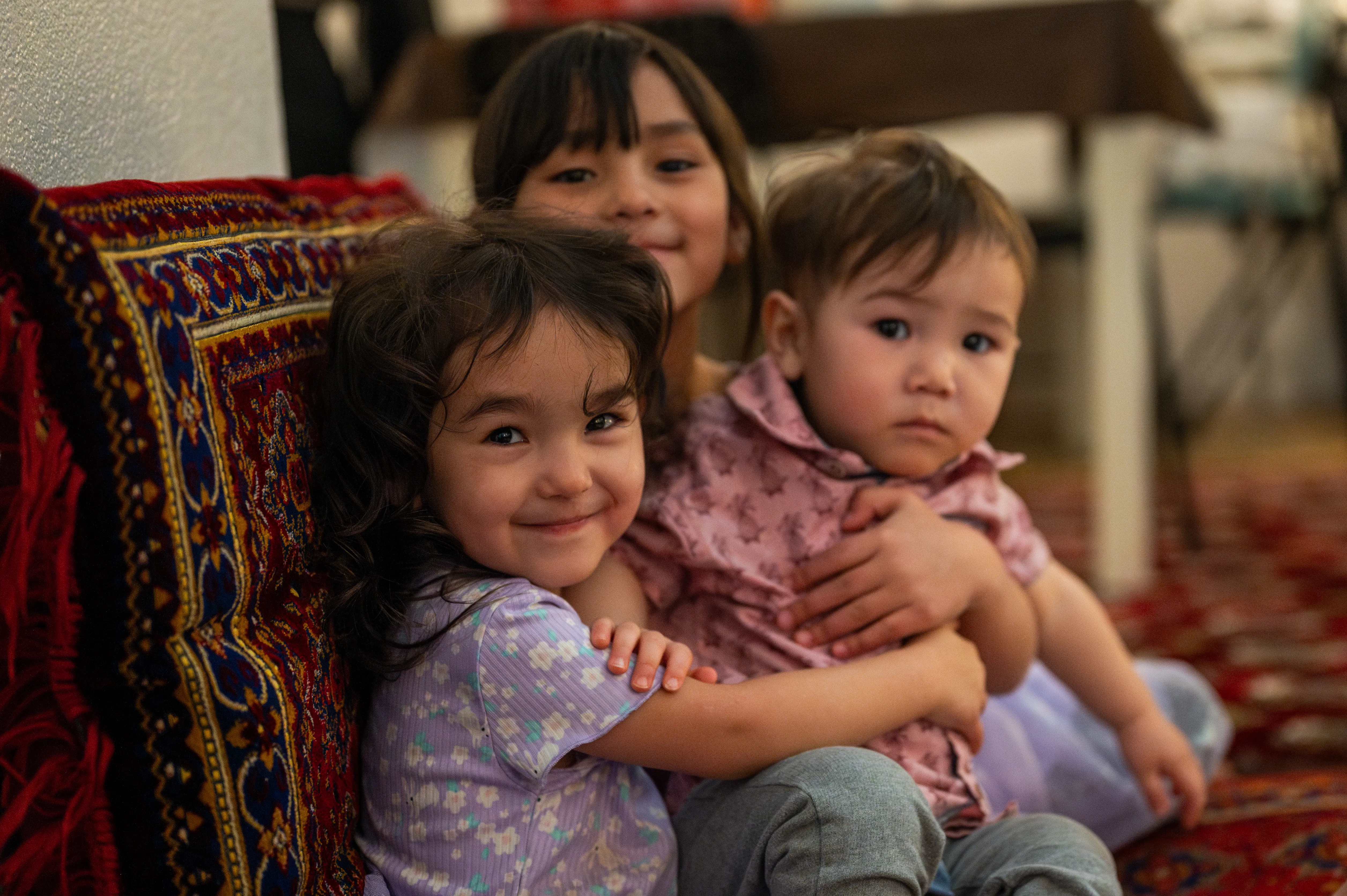 Three adorable young children hugging before a Ramadan iftar meal