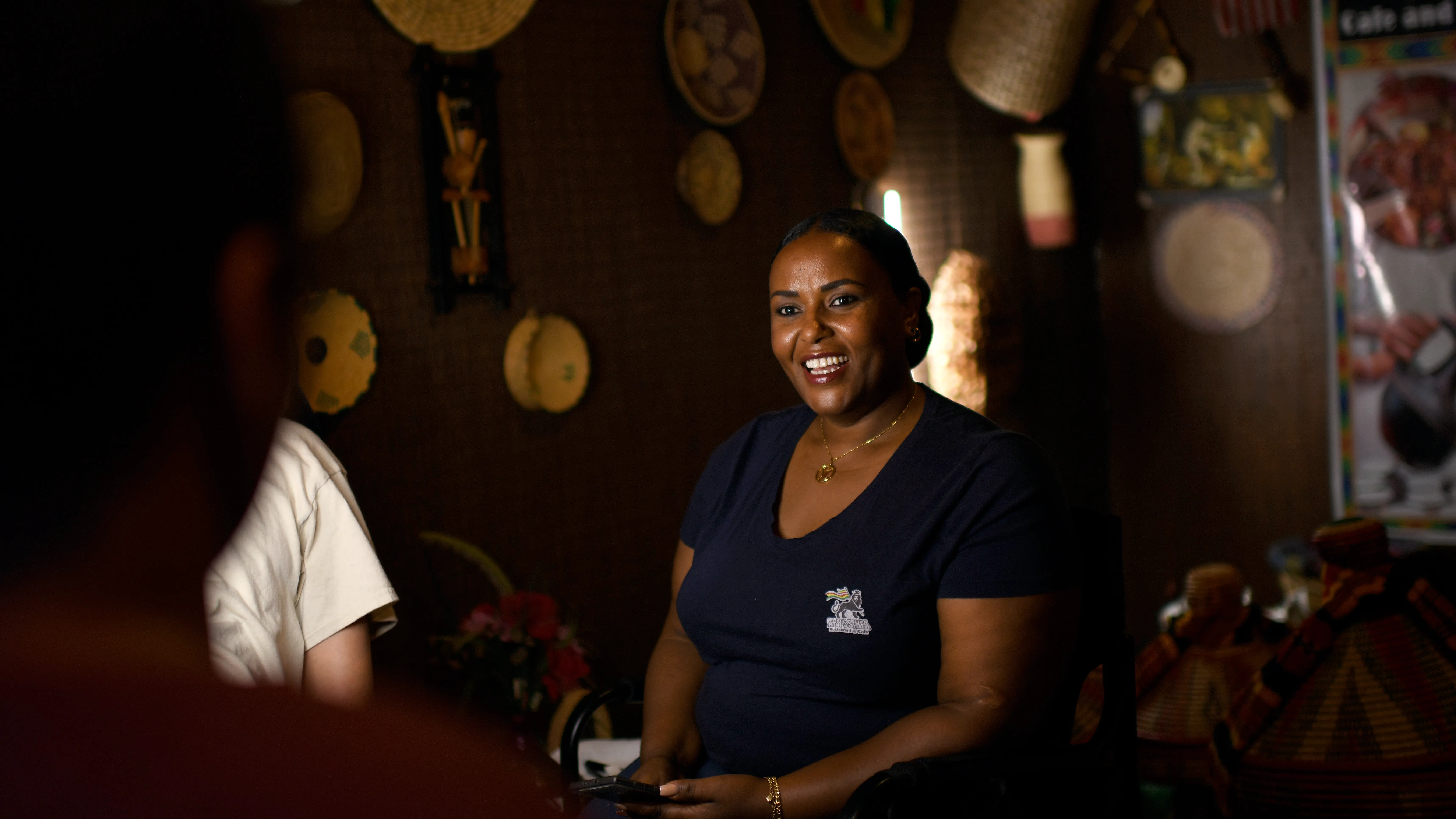 A woman smiles while working in an Ethiopian restaurant 