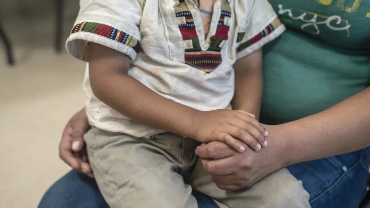 A child sits on his mother's lap