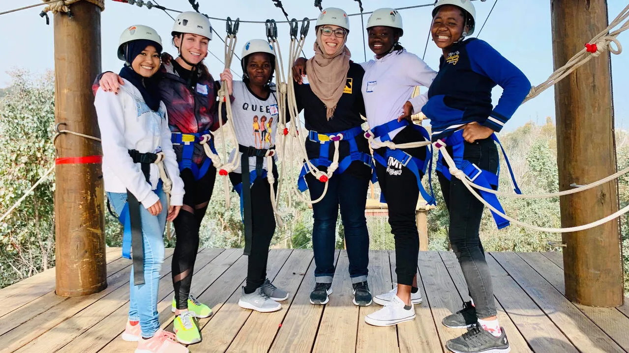 Women stand together and smile during an outdoor activity 