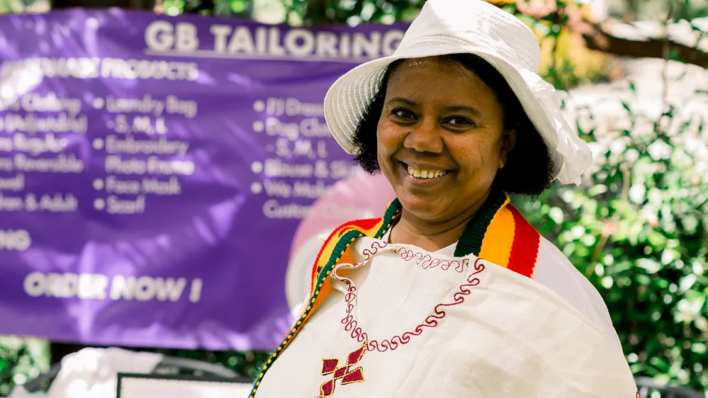 Woman smiles at an outdoor event for women's empowerment 