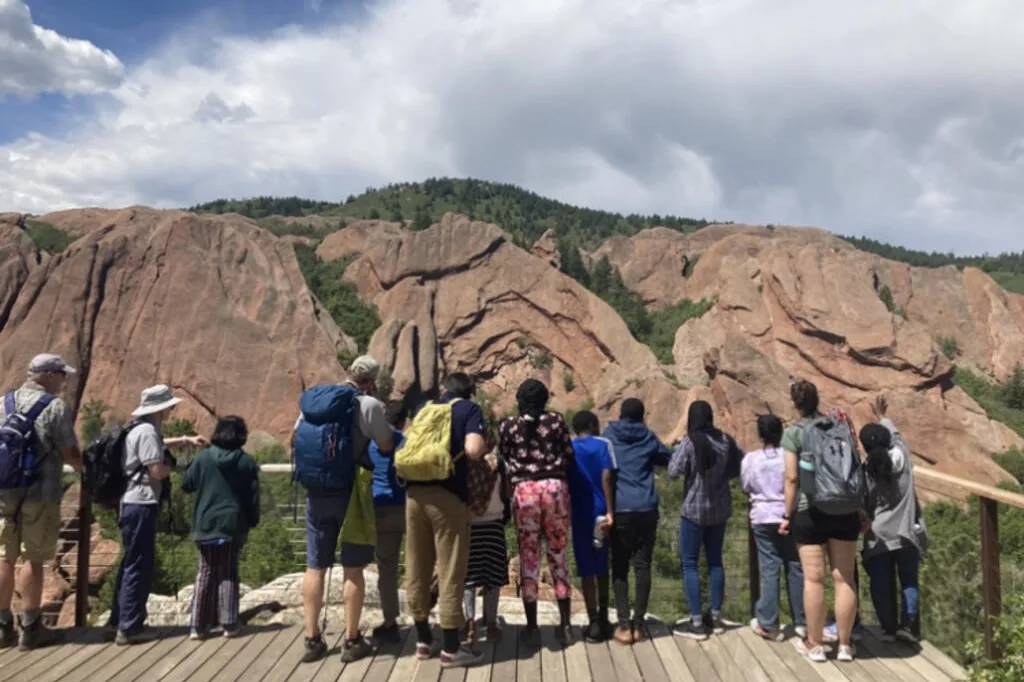 A group of people looking towards a mountain