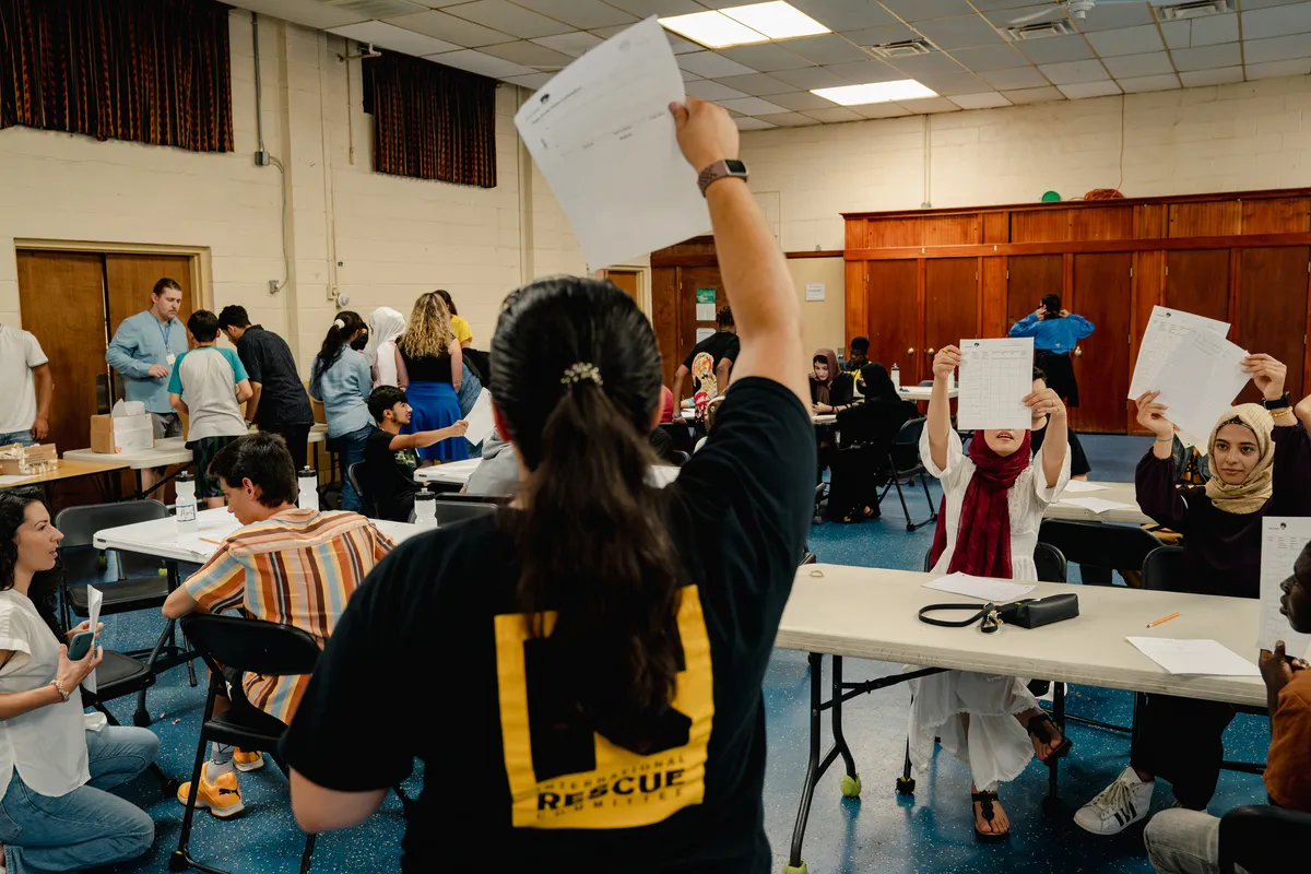 Students show their assessments to a staffer