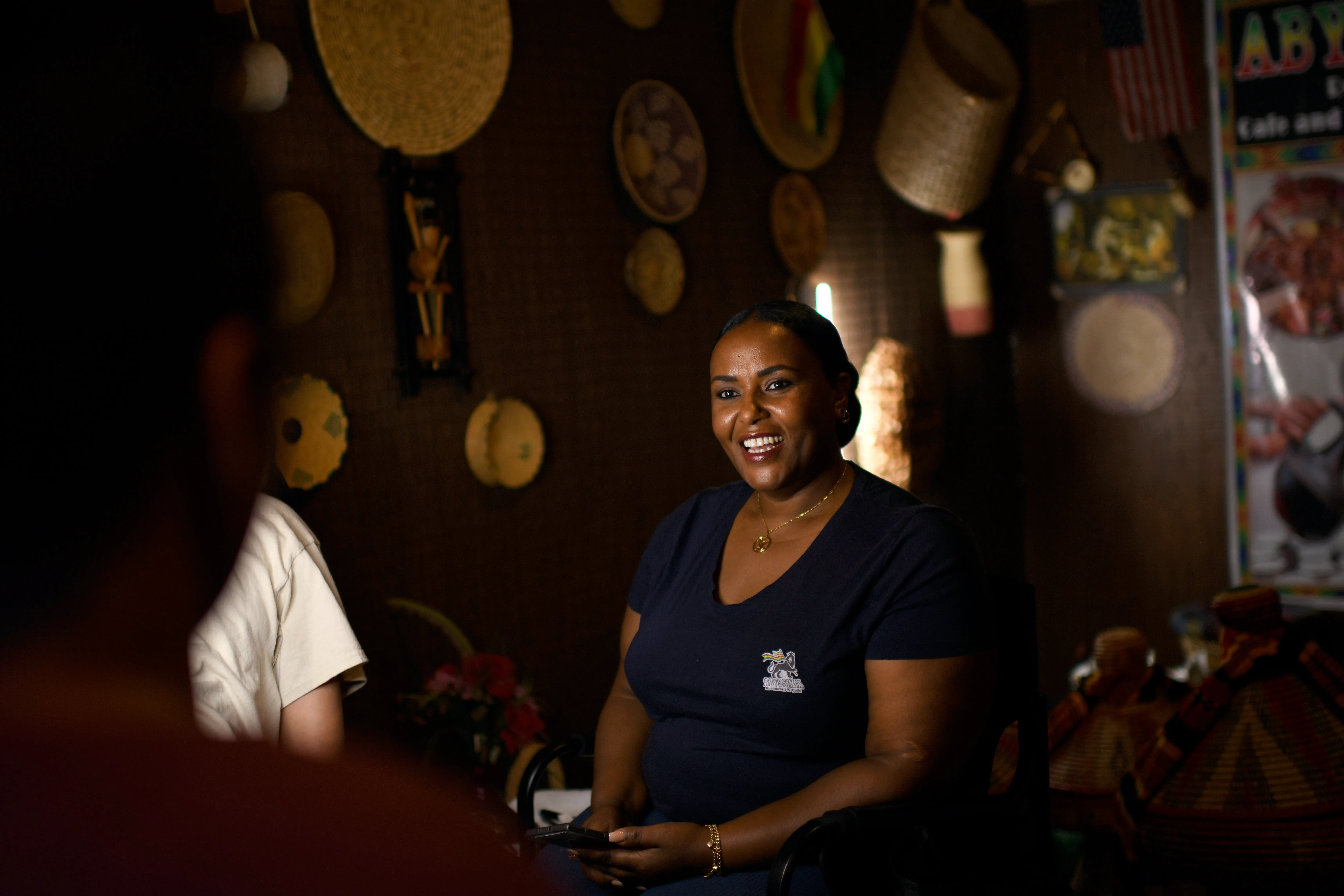 A woman smiles while working in an Ethiopian restaurant 
