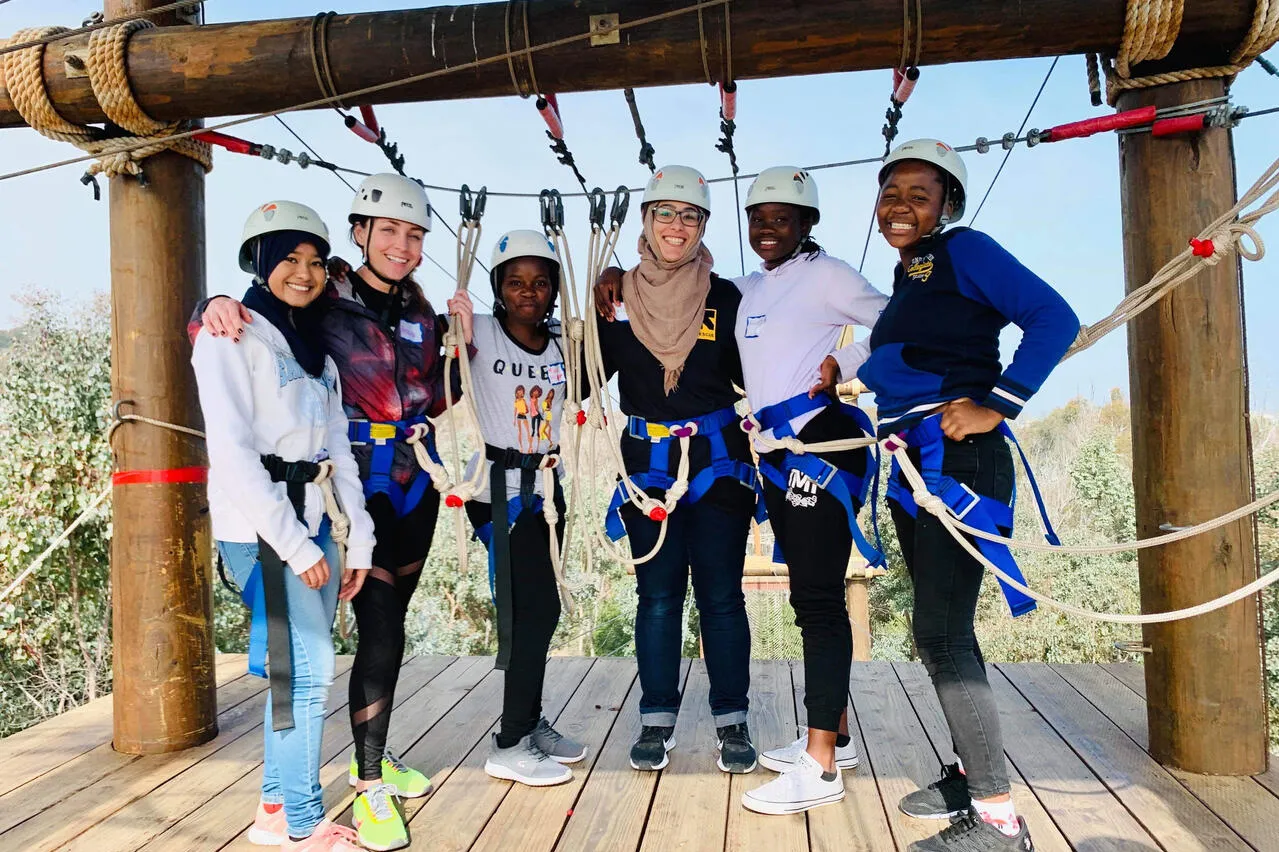 Women stand together and smile during an outdoor activity 