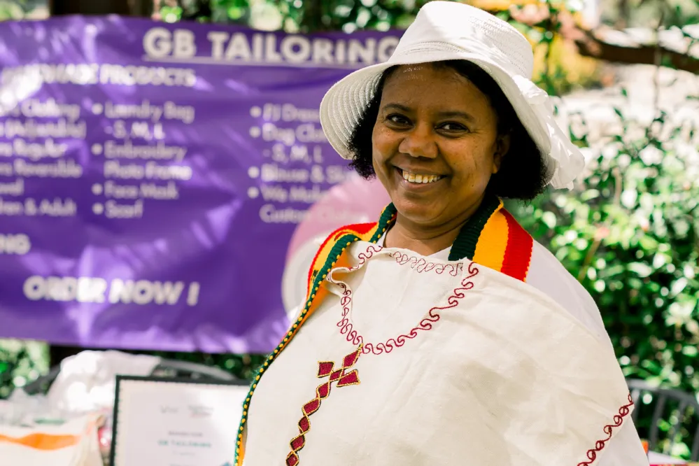 Woman smiles at an outdoor event for women's empowerment 