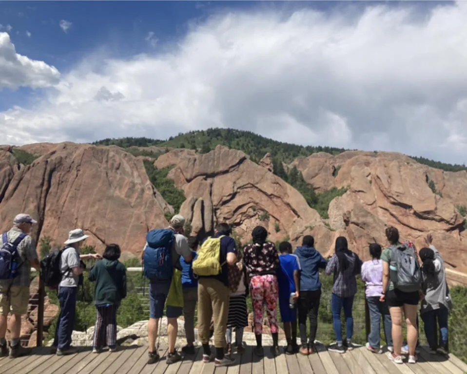A group of people looking towards a mountain