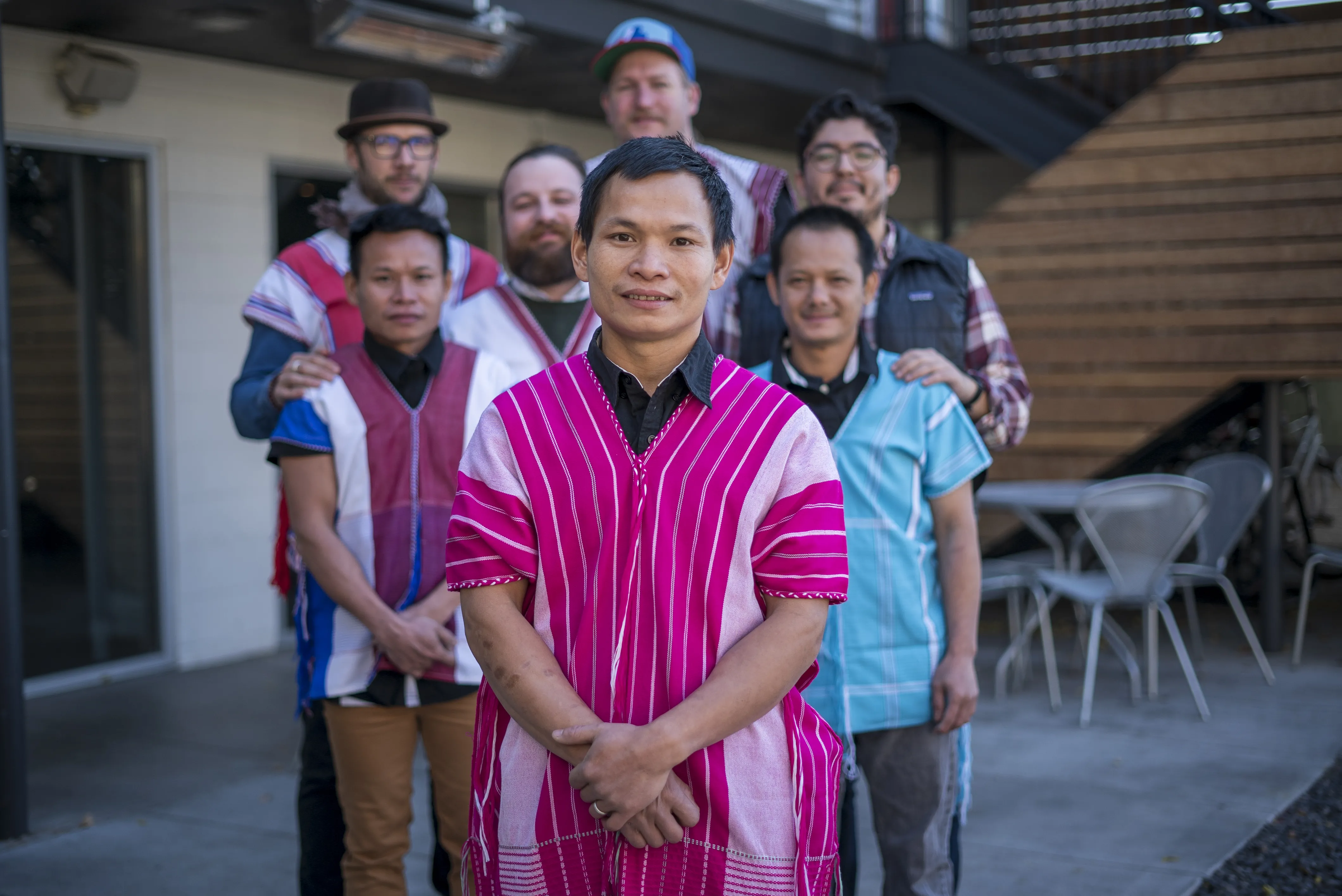 Dah Bu and his coworkers stand together for a group photo. Dah Bu and his friends are wearing traditional Burmese outfits. 